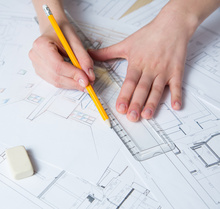 hands drawing a design with a pencil and ruler
