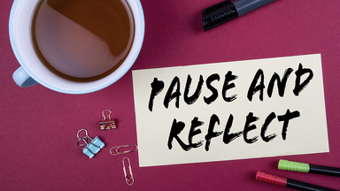 tea in a mug and a sticky note wiht the text pause and reflect